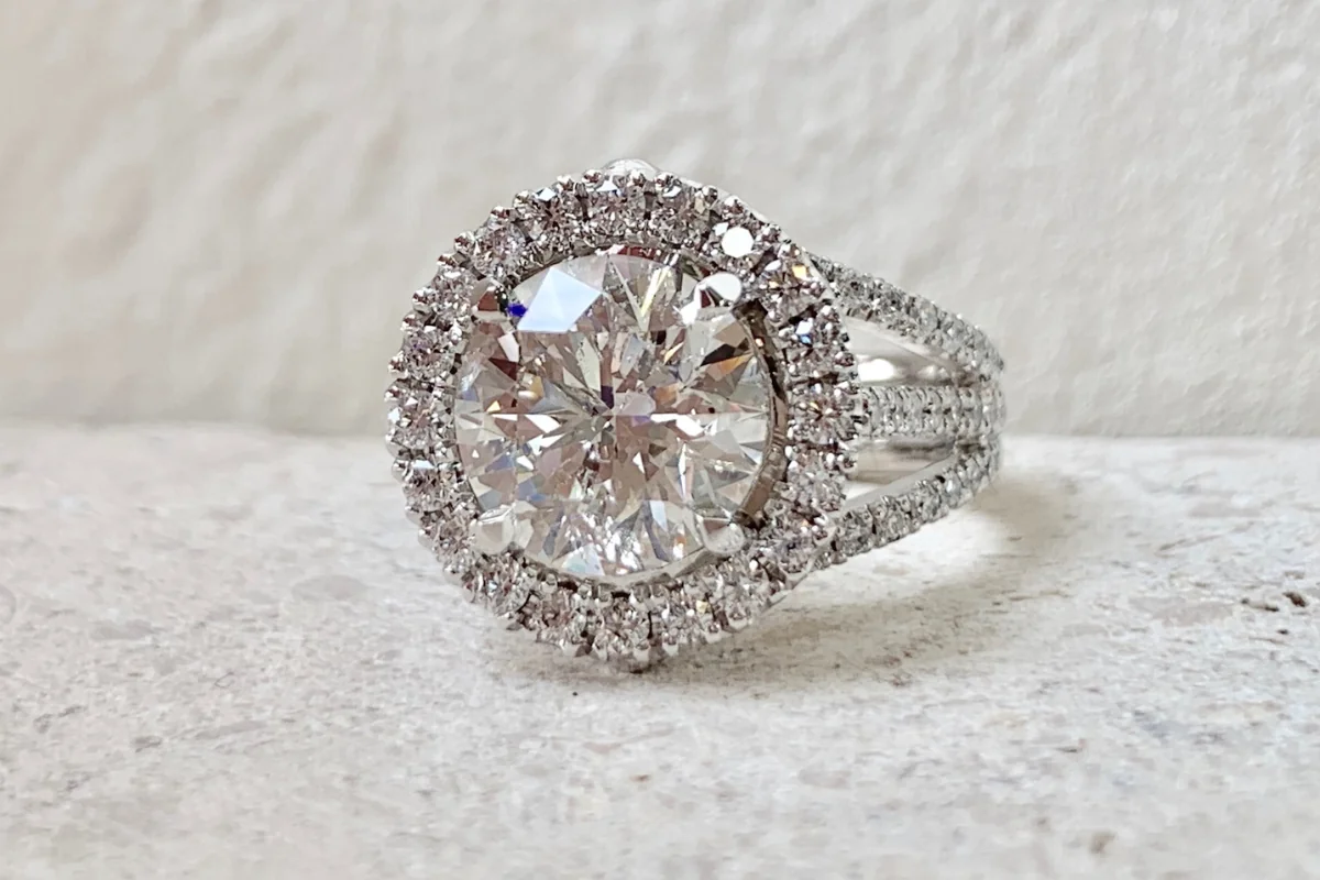 Round diamond engagement ring with melee diamond halo and band