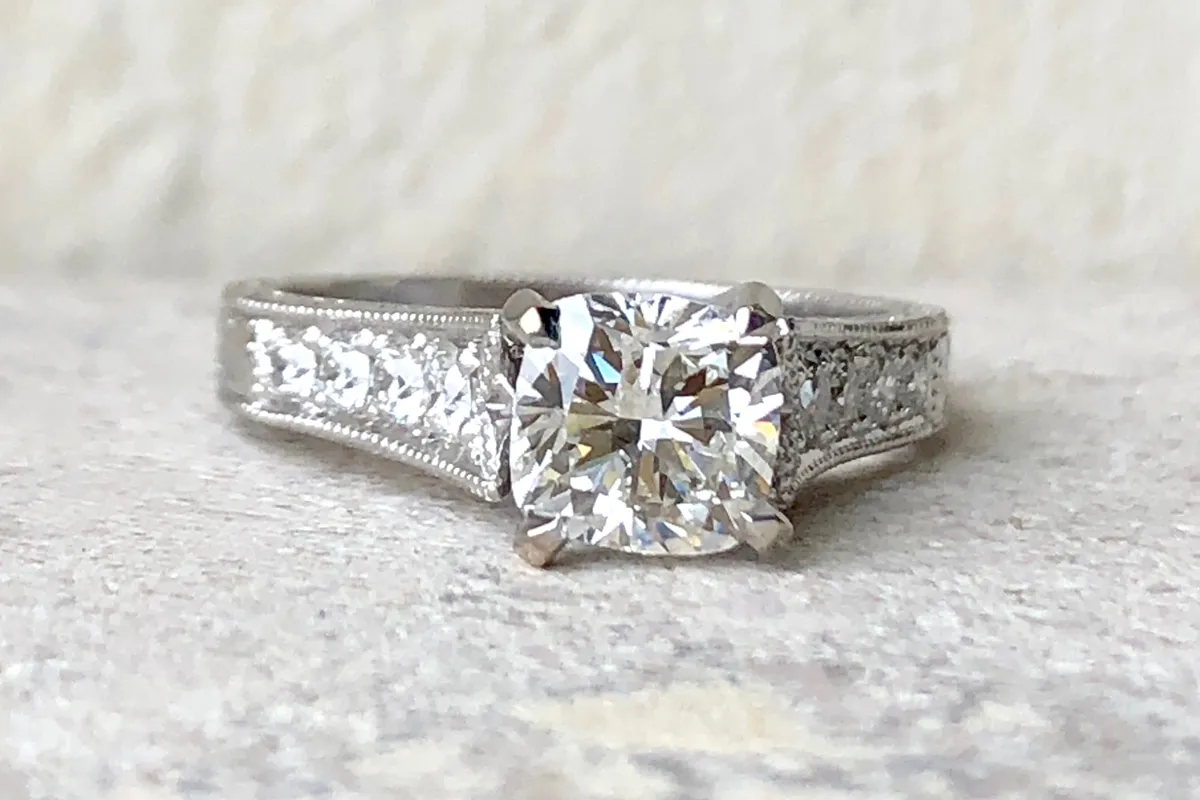 silver ring displayed on light stone